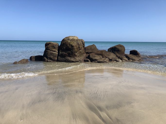 Fels in seichten Wasser